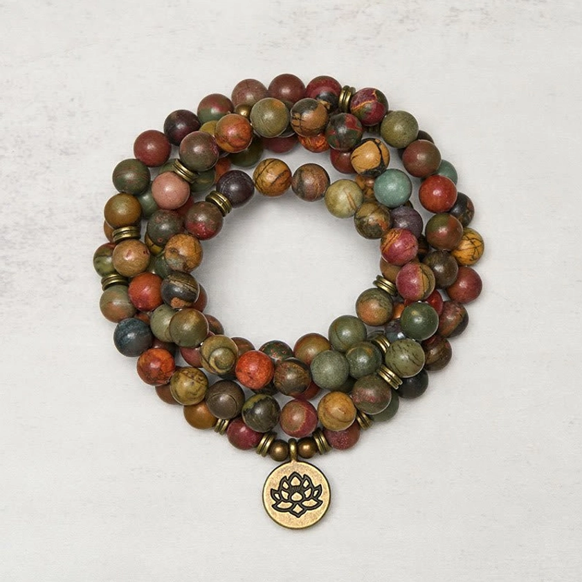 Red turquoise lotus mala beads flat lay with brass lotus charm pendant and mixed gemstone beads