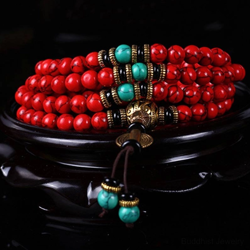 Sacred prayer mala necklace with red turquoise beads and turquoise spacers, side view on display stand