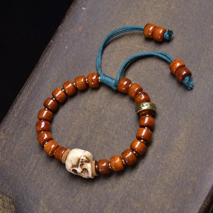 Resin brown skull bead bracelet with blue elastic cord and metal accents