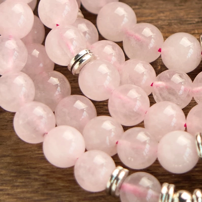 Close-up detail of 8mm rose quartz natural stone beads with silver metal spacers, high resolution
