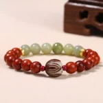 Rosewood and cyan jade Buddhist bracelet with lotus Bodhi seed centerpiece, displayed on wooden surface from overhead angle