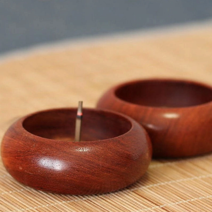 Top-down view of rosewood meditation incense burner with lit incense stick, displaying circular opening and polished surface