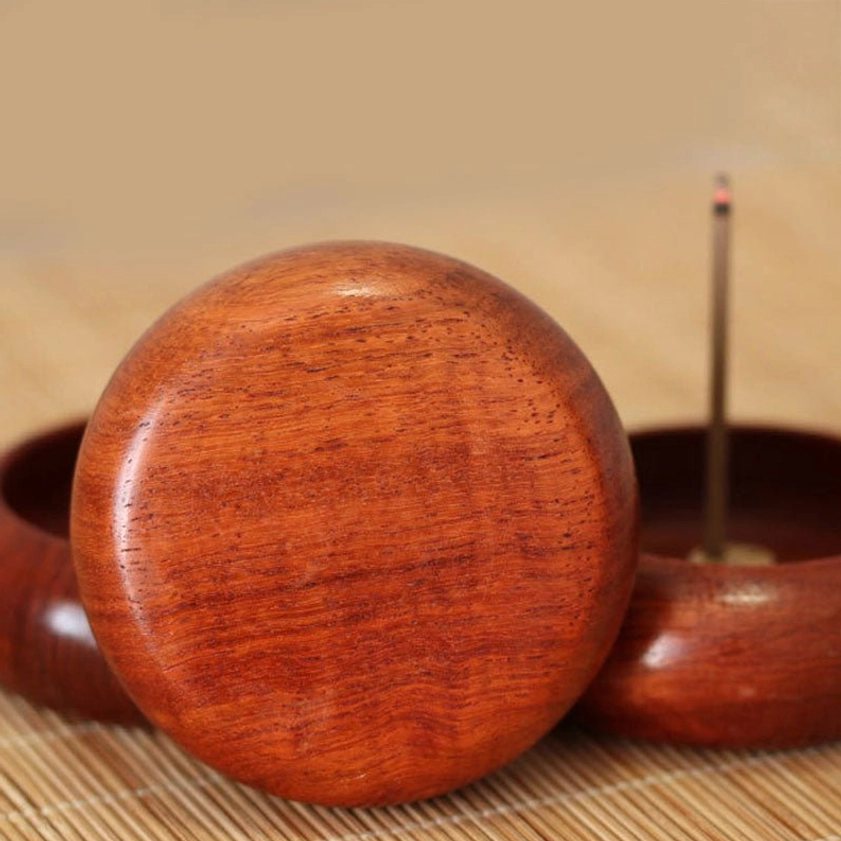 Back view of round wooden incense holder showing smooth polished rear surface and natural rosewood grain pattern