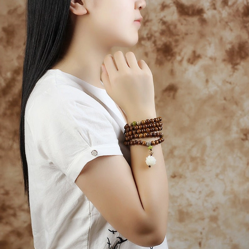 Wearable rosewood lotus mala bracelet stacked on forearm, showing practical everyday wear styling