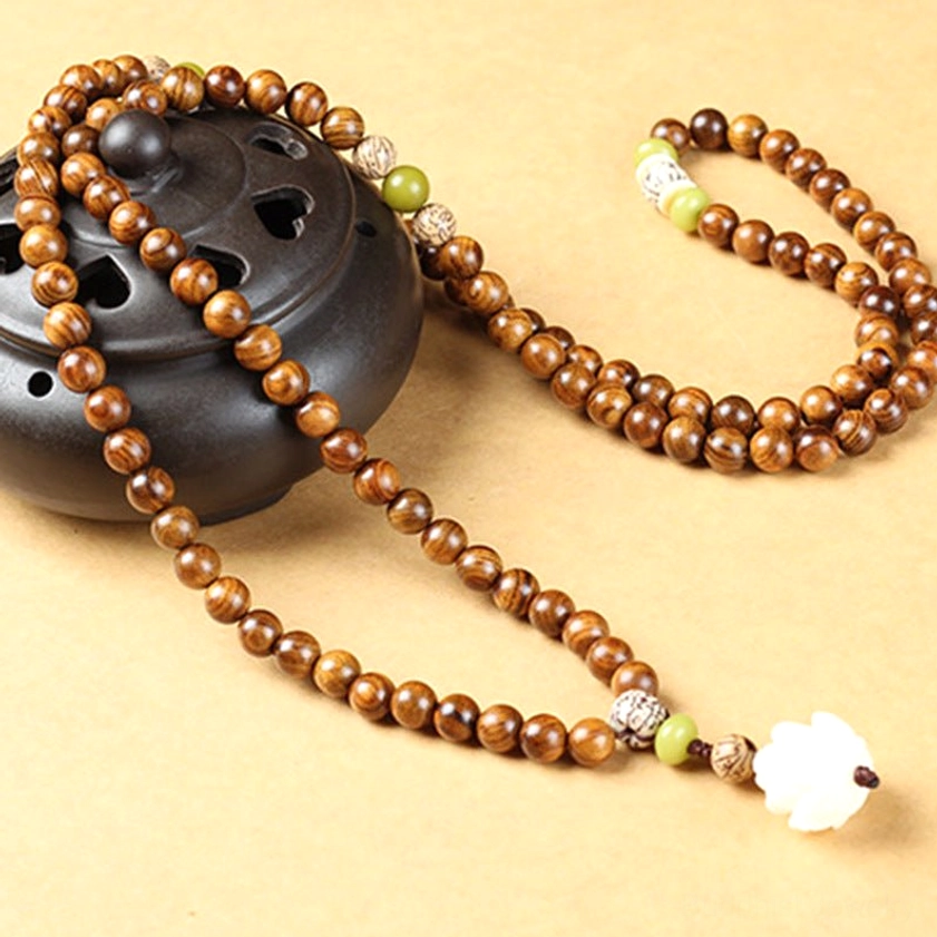 Full length rosewood lotus mala necklace with 108 beads laid flat, showing white lotus end pendant