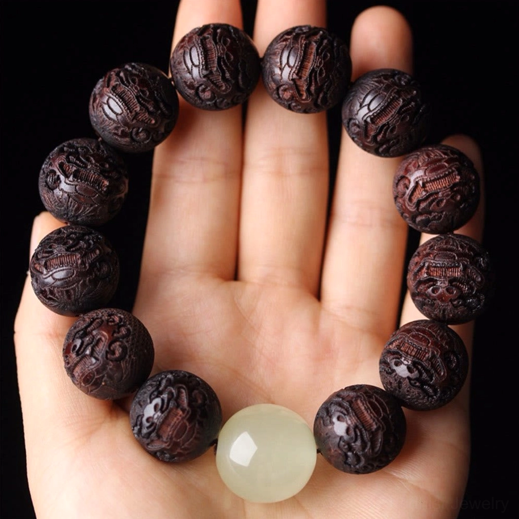 Complete rosewood Pixiu Buddhist bracelet displayed on open palm with aligned carved beads