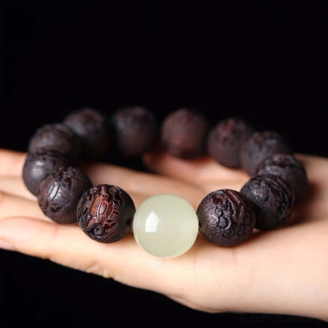 Handmade rosewood Pixiu bracelet held in palm showing loose beads and authentic carving details