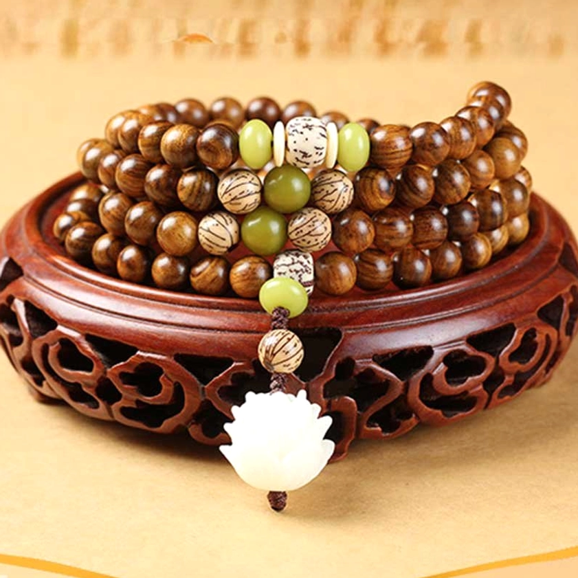 Stacked rosewood Buddhist prayer malas displaying reddish-brown wood grain and decorative bead accents