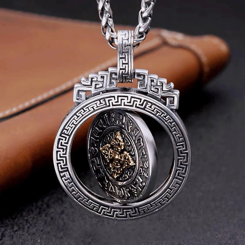 Hollow rotatable Buddhist pendant on twisted silver chain showing inner spinning disc for meditation practice