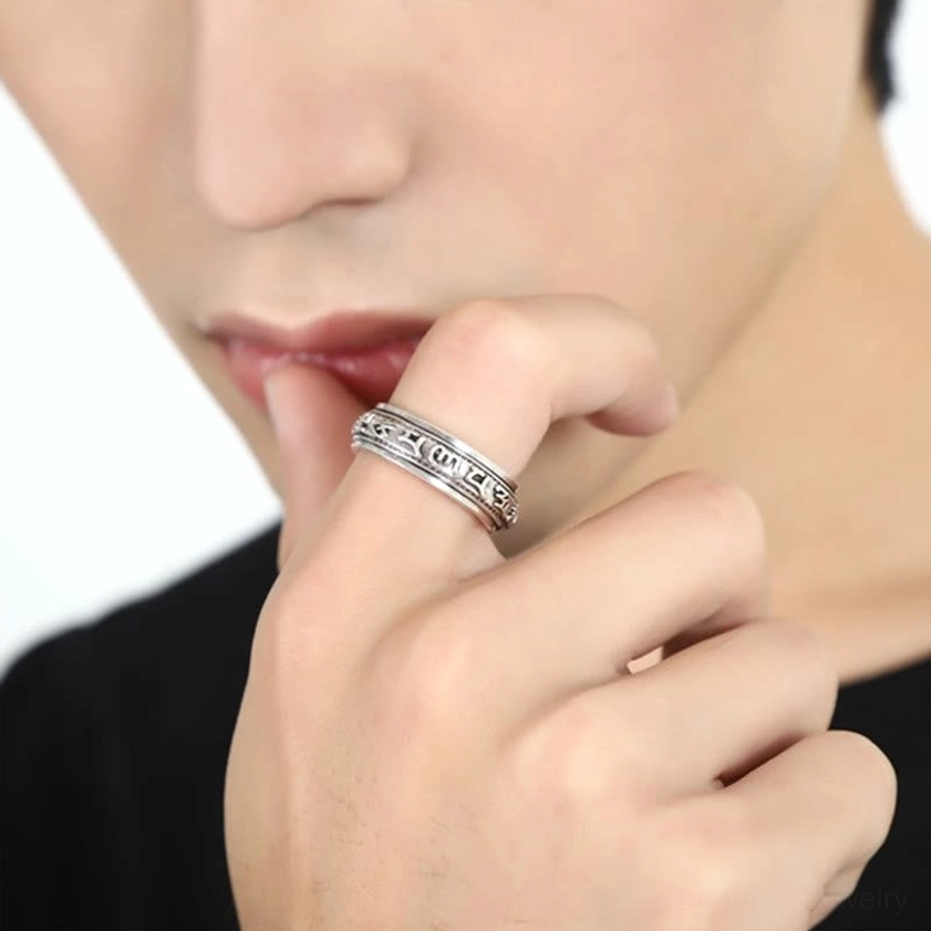 Spiritual buddhist ring worn on index finger demonstrating simple daily wearing style with black casual clothing background