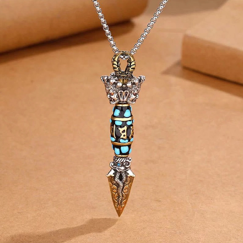 Rotatable Om Mani Padme Hum dzi bead dorje pendant necklace, top-front flat lay displaying turquoise-inlaid six-word mantra, mixed metal tones