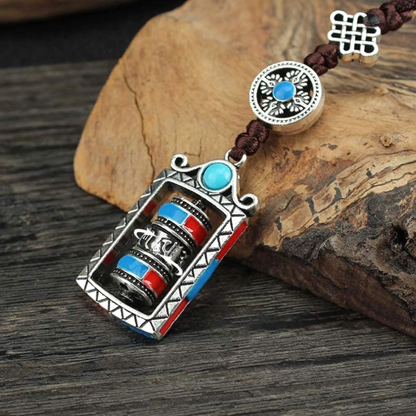 Rotatable prayer wheel keychain with blue-centered charm and ornate silver metal frame