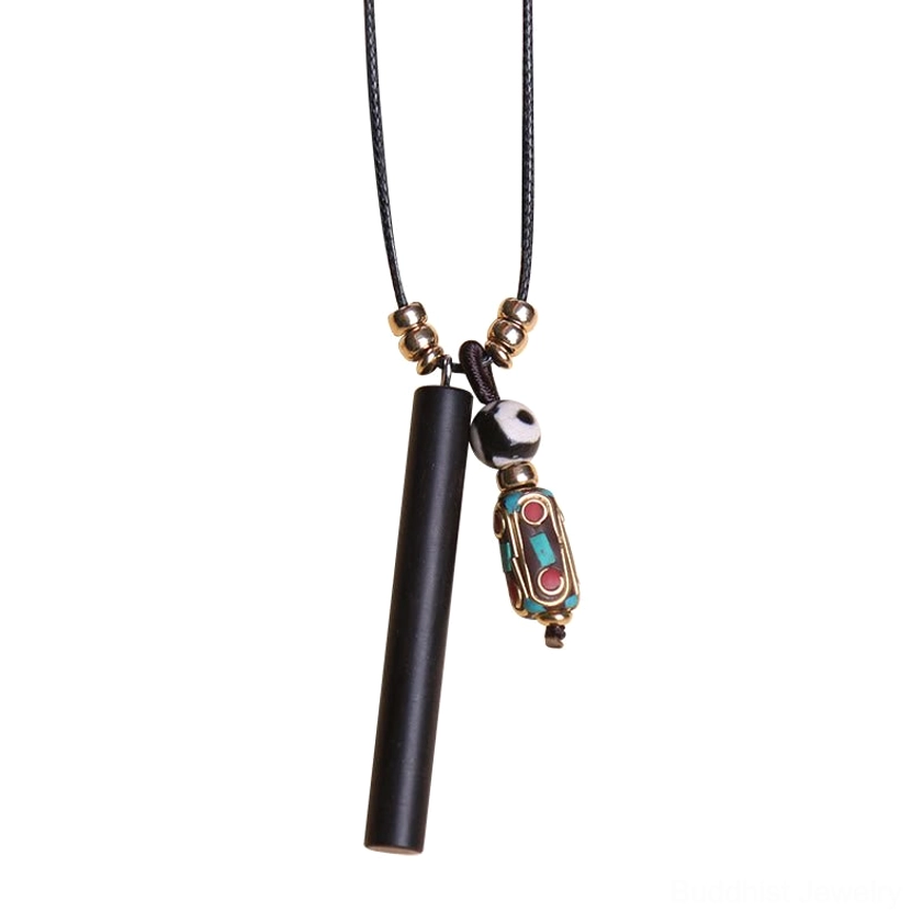 Ebony wood round dzi charm pendant with light blue accent bead on indigo blue fabric with lotus pod