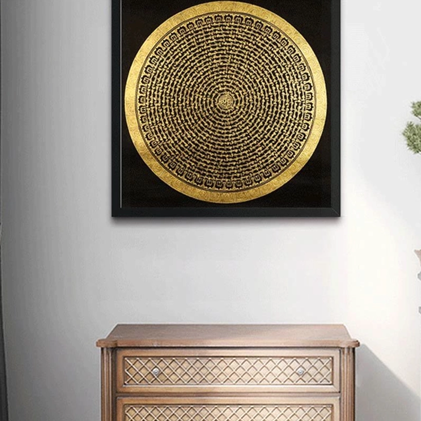 Round mandala thangka wall art displayed above wooden cabinet - Buddhist home interior decoration