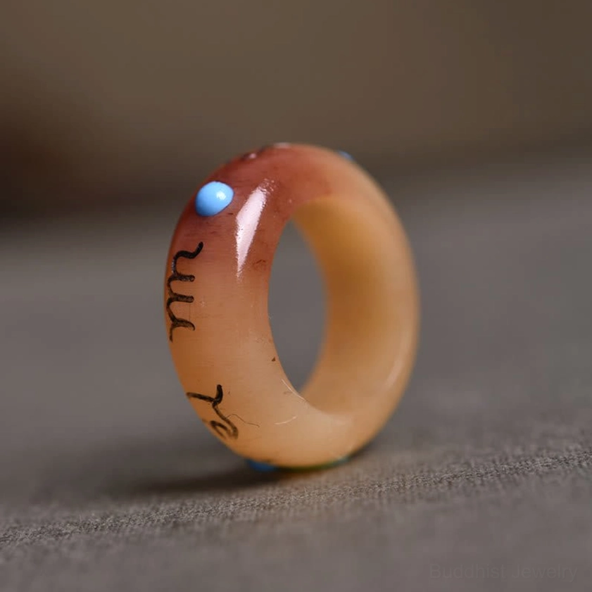 Round profile carved bone Buddhist mantra ring - side view showing full Sanskrit engraving and blue spiritual bead