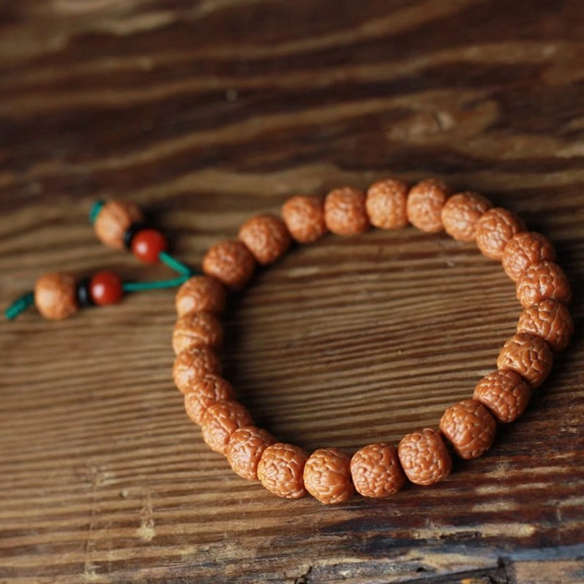 Buddhist Rudraksha Bodhi seed bracelet overhead flat lay on dark wooden background