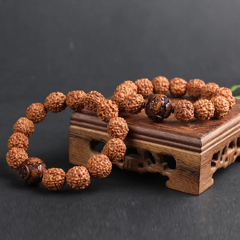 Multiple Rudraksha Bodhi bracelets and loose beads on wooden display stand low-angle flat lay shot
