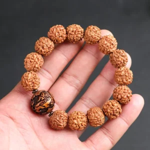Rudraksha Bodhi Seed Pixiu bracelet held in palm overhead view natural textured brown beads with carved wooden accent bead