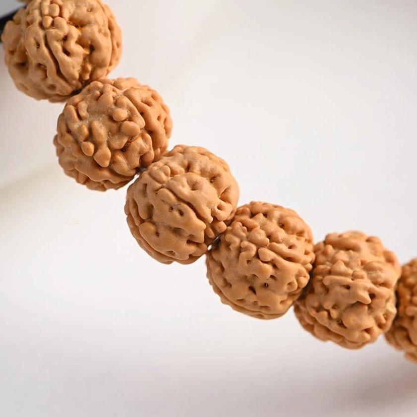 Close-up detail of hand-carved rudraksha bodhi seeds showing honeycomb texture pattern