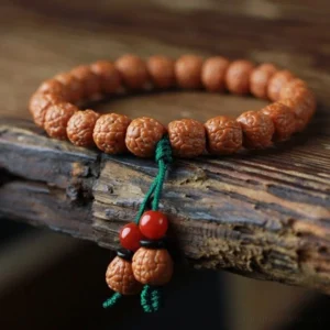Handmade Rudraksha Bodhi seed wealth bracelet with agate closeup on wooden surface