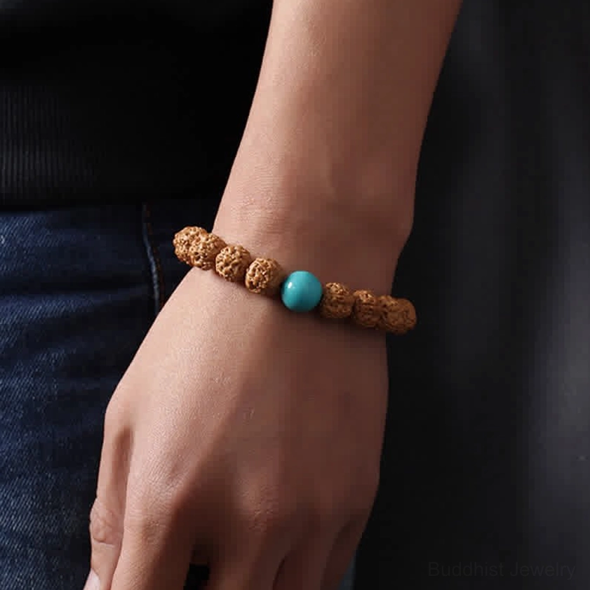 Rudraksha Bodhi Seed bracelet with turquoise bead worn on wrist demonstrating comfortable elastic fit for meditation and mindfulness practice