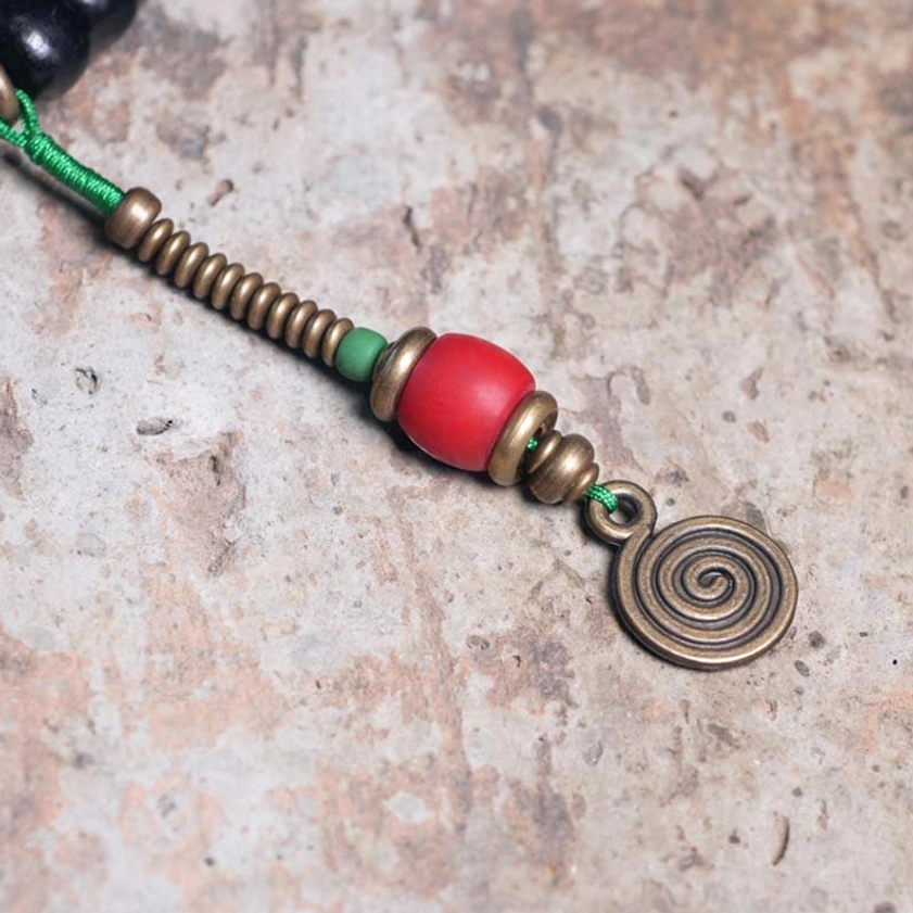 Sacred 108 bead mala prayer bracelet with protective dzi symbol and spiritual craftsmanship