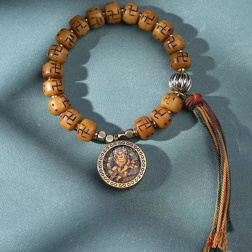 Sacred Buddhist prayer bracelet featuring camel bone beads, engraved Buddha amulet charm, and spiritual woven tassel