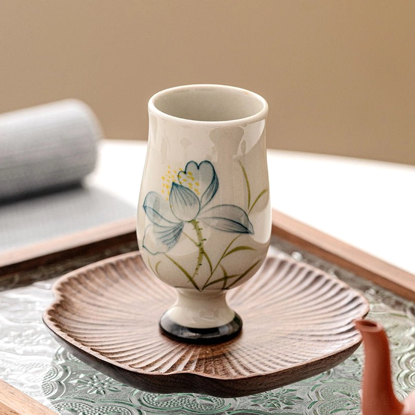 Hand-painted ceramic tea cup featuring sacred lotus flower motif for Buddhist tea ceremony and spiritual practice