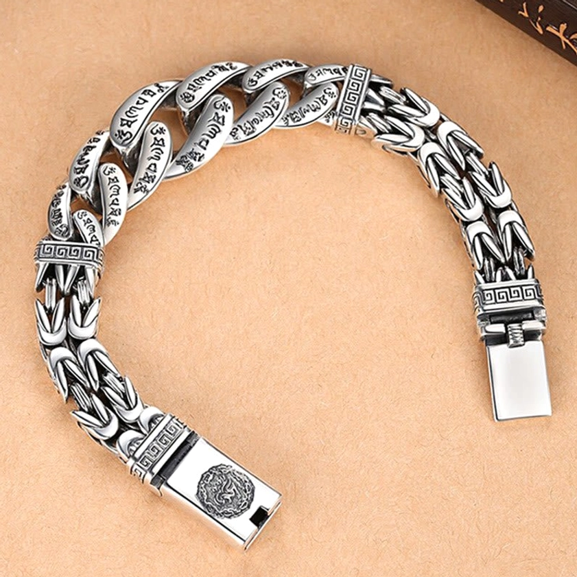 Side view of sacred mantra bracelet showing engraved mantras on woven chain and decorative carved clasps