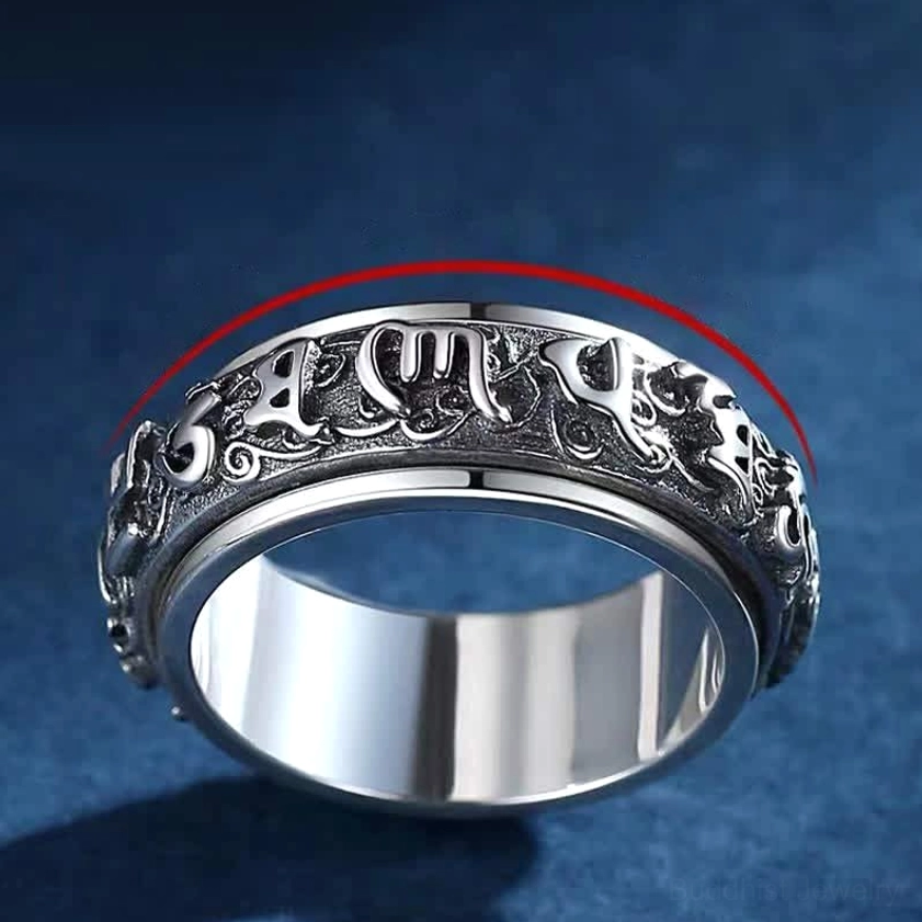 Buddhist mantra spinner ring oblique angle view with rotatable design detail indicated by red arrow