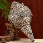 Handcrafted sacred Shankha conch shell with Eight Auspicious Symbols, turquoise and red gemstone inlays on wooden display stand