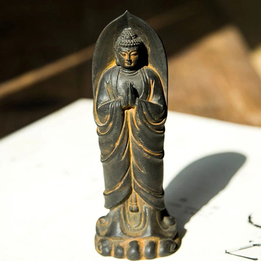 Sakyamuni Buddha Namaste meditation statue front-facing view with prayer hands and detailed halo, white background with wooden backdrop