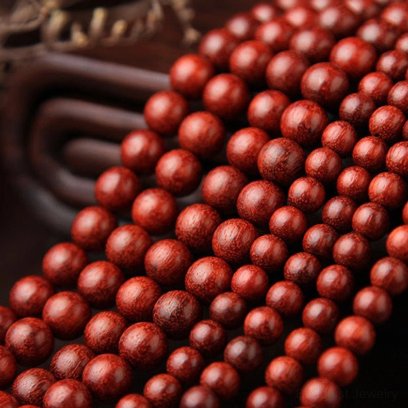 Macro photography of red sandalwood prayer beads displaying fine wood grain and natural color variation