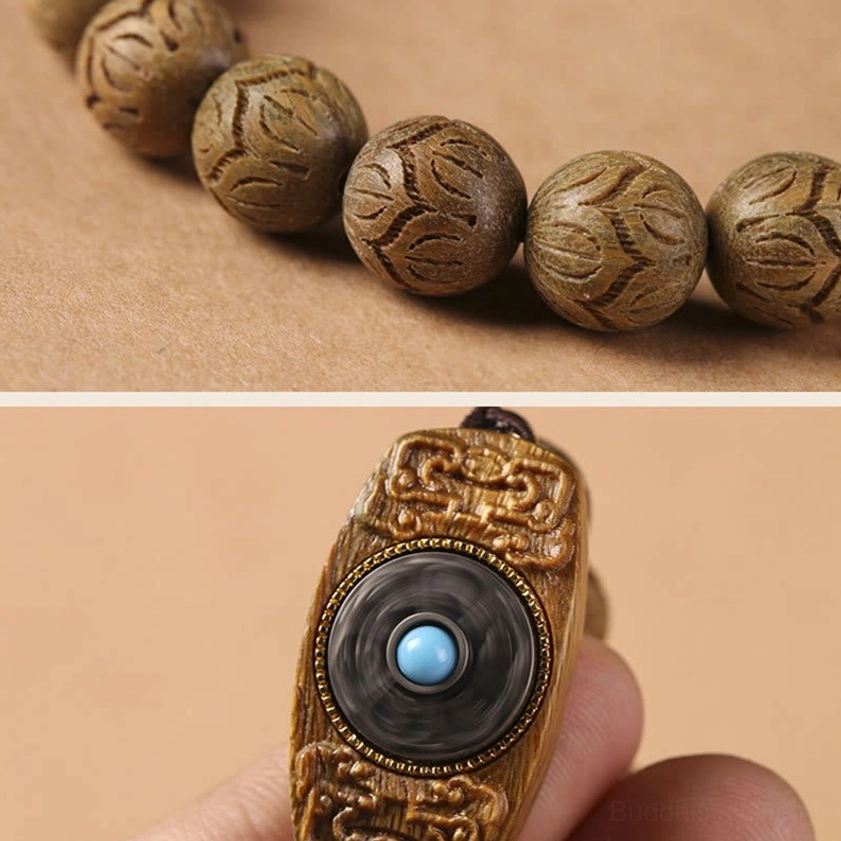 Close-up macro shot of engraved sandalwood beads with floral patterns and turquoise inlaid charm