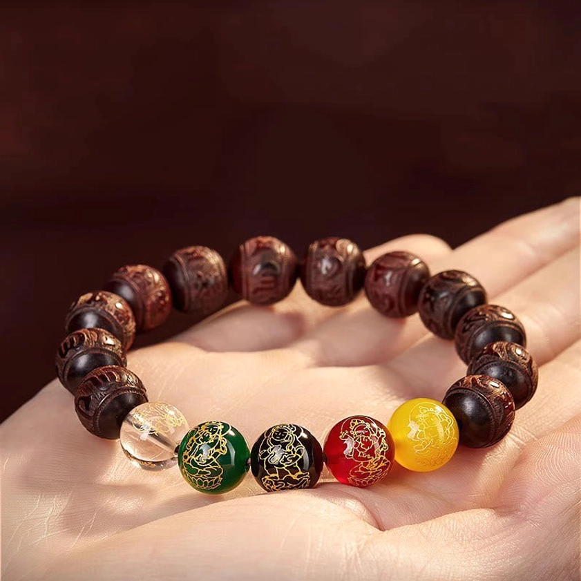 Red sandalwood bracelet held in human palm showing actual wrist size and bead dimensions