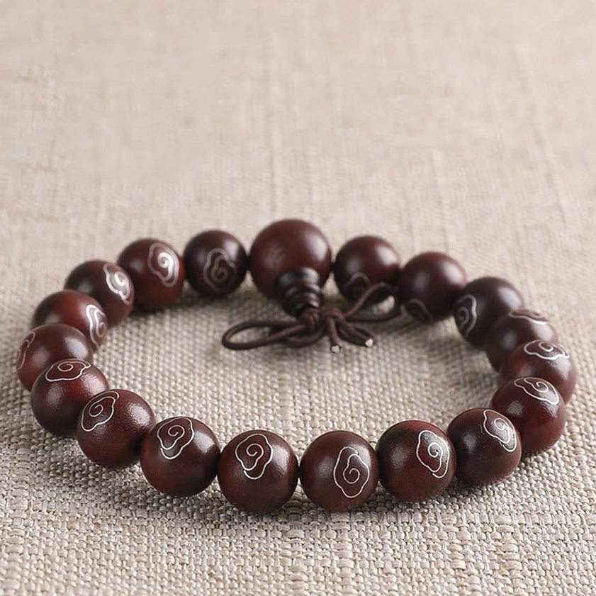 Single-loop red sandalwood bracelet with 925 sterling silver cloud and Om Mani Padme Hum character inlays overhead view
