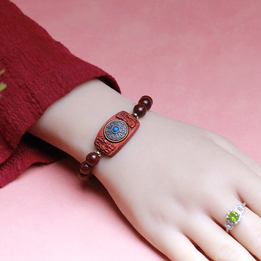 Woman wearing red sandalwood Buddhist bracelet on wrist with red clothing, close-up lifestyle shot
