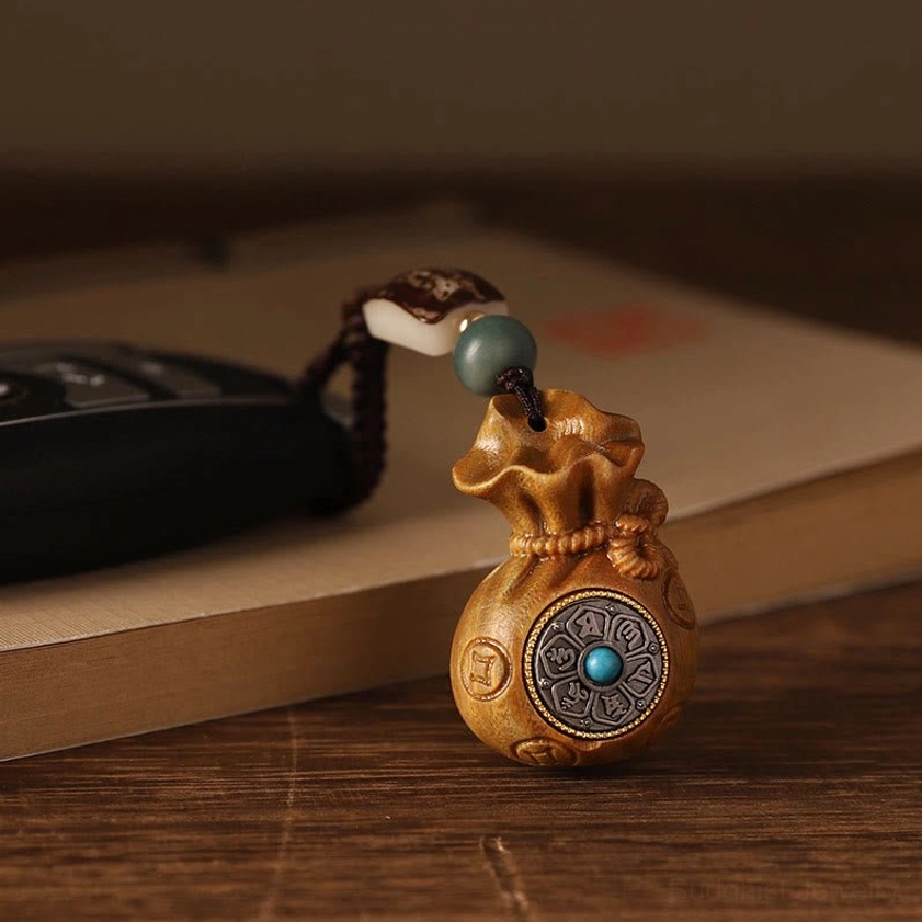 Sandalwood Buddhist charm showing natural wood grain and texture of handcrafted money bag pendant