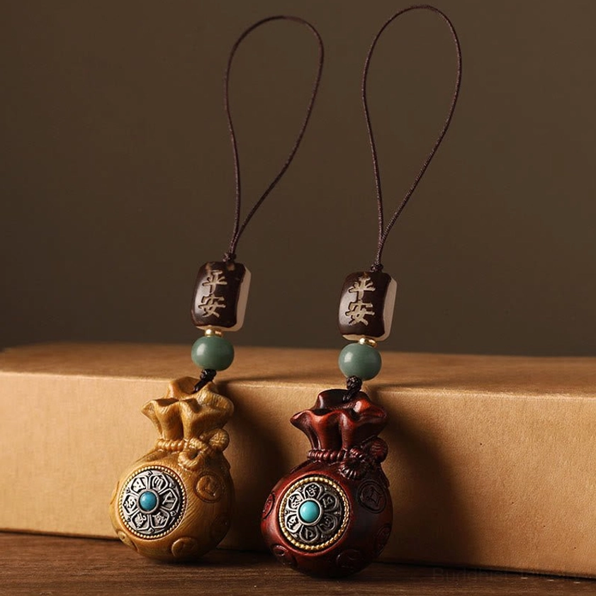 Red and green sandalwood Buddhist charm variants ready to wear as keychain or phone decoration talisman