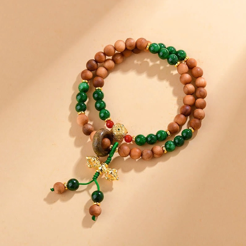 Sandalwood Dorje Vajra double twisted bracelet top view with brown wooden beads, green jade accents, and gold Dorje charm