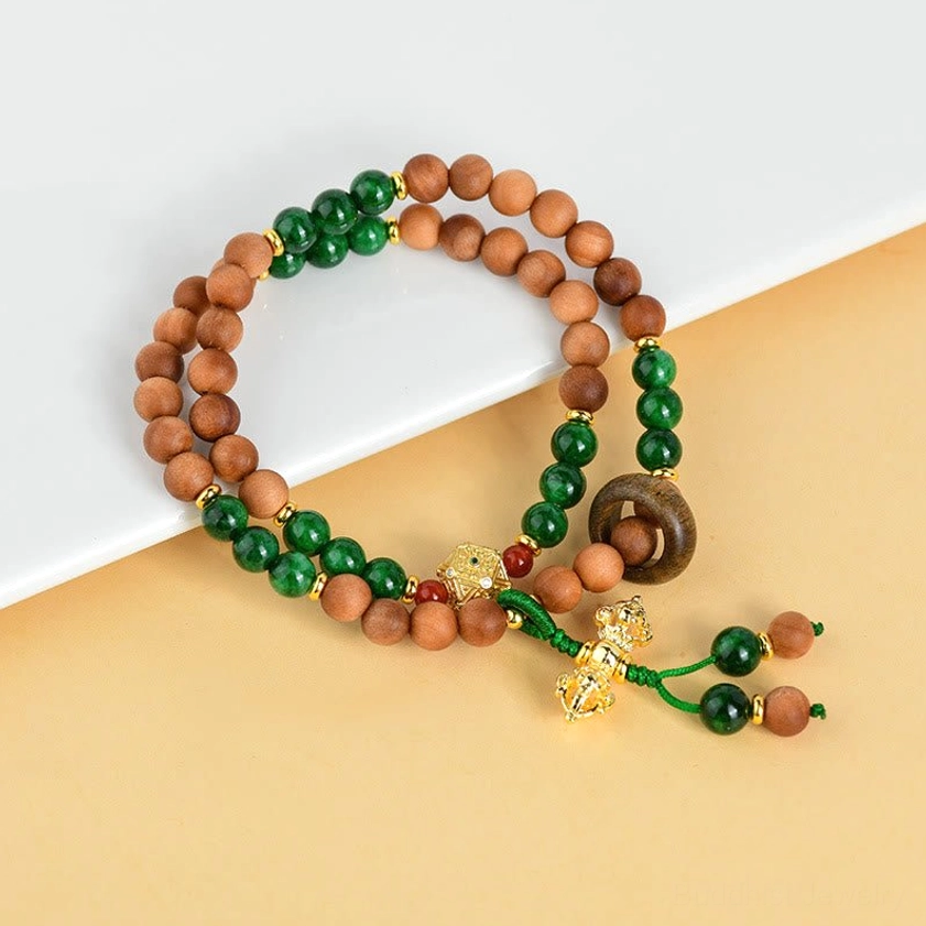Sandalwood protective bracelet with dark green jade beads and gold Dorje pendant detail