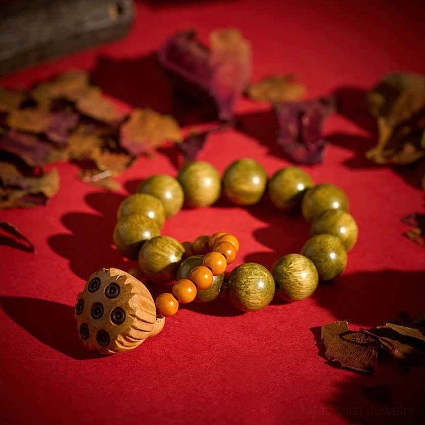 Single sandalwood lotus meditation palm beads in overhead flat lay arrangement with dried leaf décor, showing full bracelet layout and matte wood finish