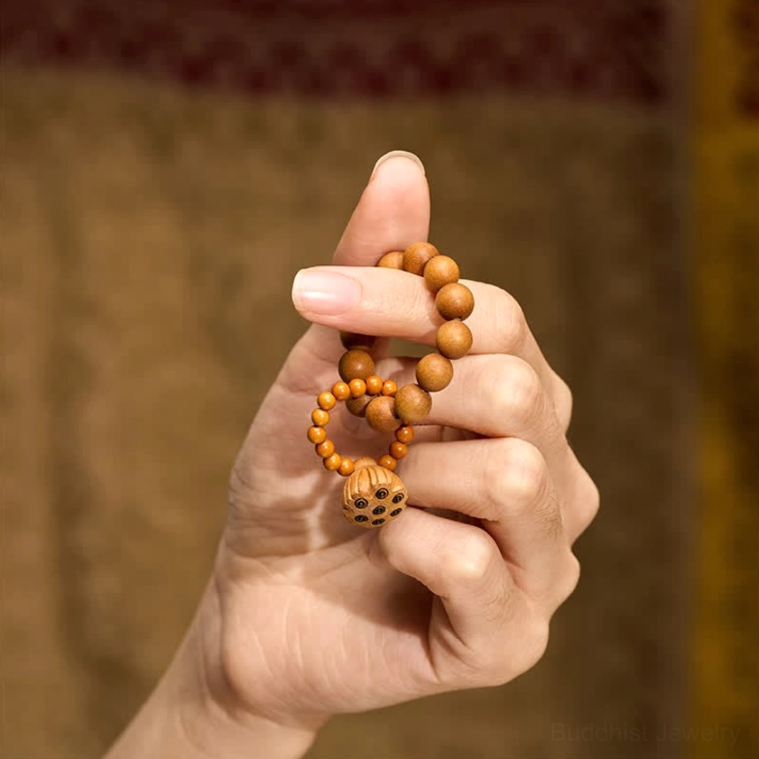 Sandalwood lotus meditation palm beads close-up of individual beads showing natural wood color variations, hand-polished surface, and authentic grain texture
