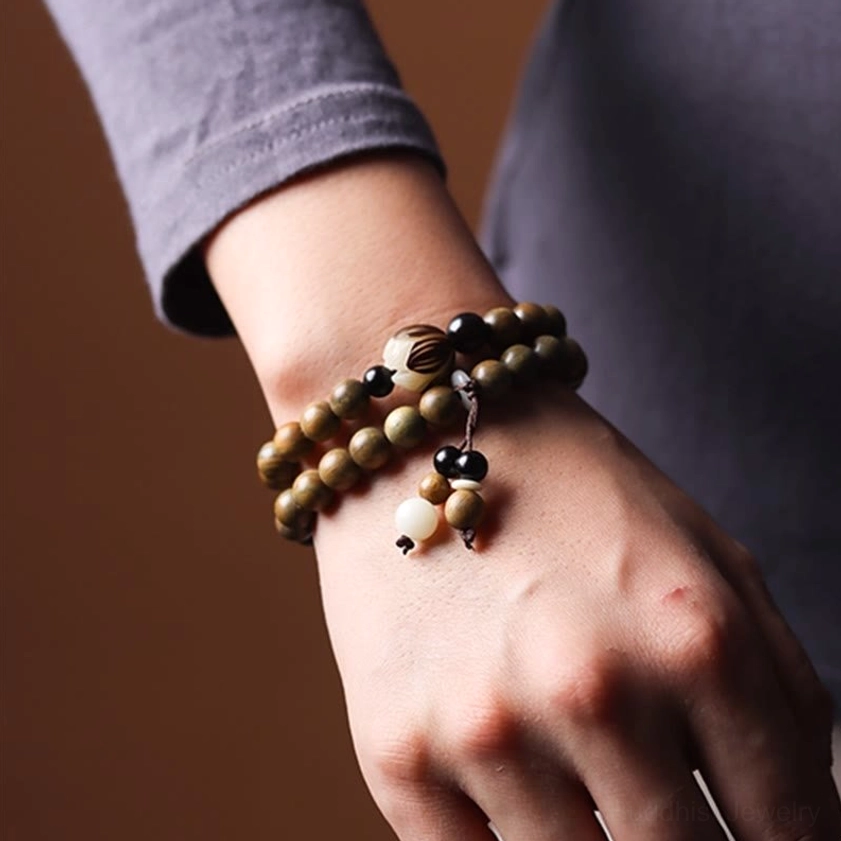 Multiple green sandalwood lotus bracelets arrangement showcasing color variation and natural oxidation process of sandalwood beads