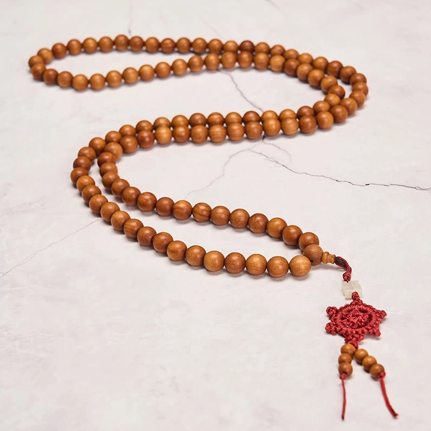 Handcrafted red sandalwood mala closeup detail showing bead texture and craftsmanship