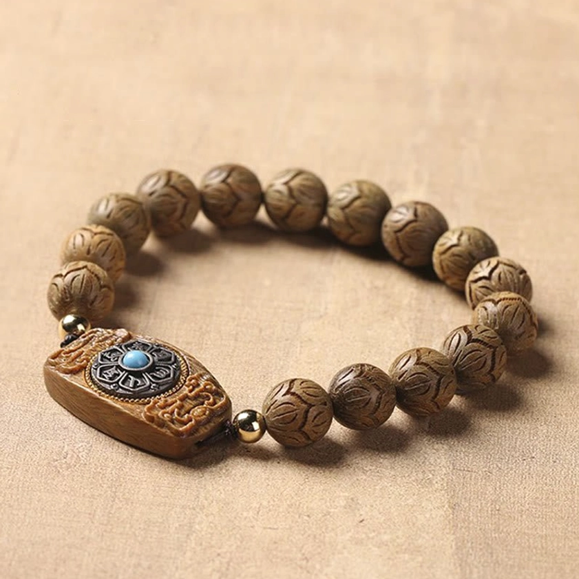 Sandalwood carved mala bracelet with detailed central charm, neatly arranged beads
