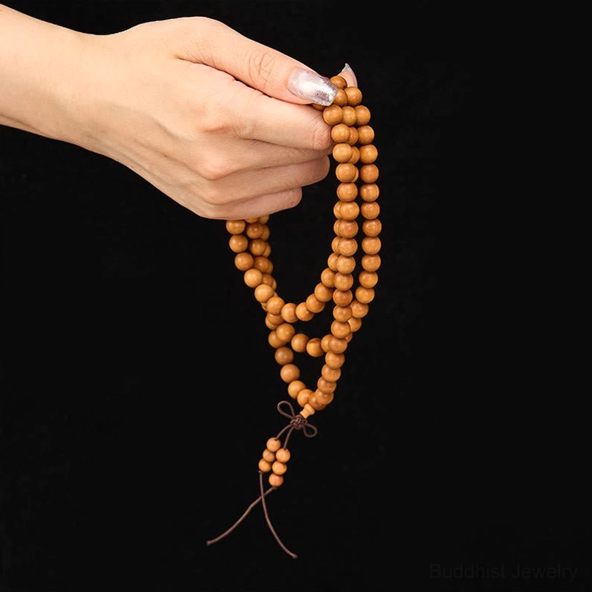 Sandalwood prayer mala with red tassel detail showing traditional Chinese knotting technique