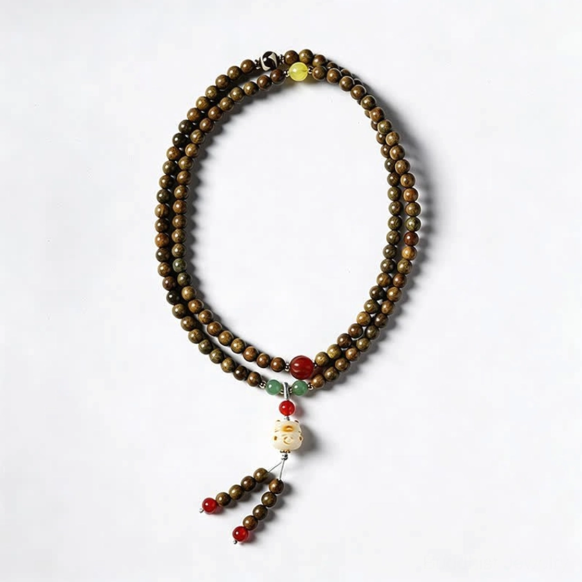 Simple sandalwood beaded mala with decorative beads and cat tassel on plain white background