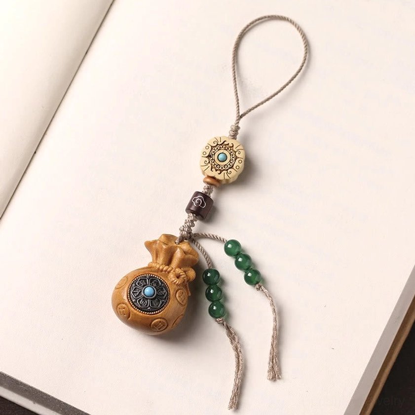 Carved sandalwood Om Mani Padme Hum charm showing Buddhist mantra in sacred script with natural patina