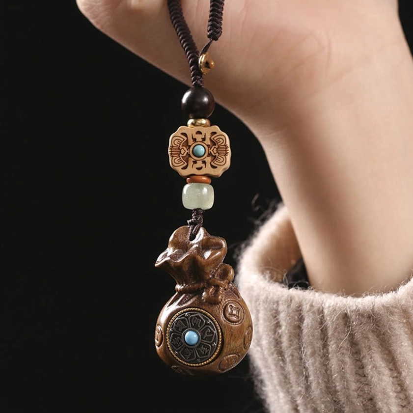 Sandalwood Om Mani Padme Hum keychain worn on knit sweater sleeve showing daily wear styling